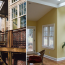 A diptych showing exterior deck stairs and interior of sunroom with skylights, yellow walls, and hardwood floors.