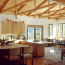 A kitchen and dining area with vaulted ceiling, exposed beams, and lots of natural light.