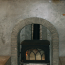 A closeup of a custom concrete fireplace with a woodstove in it.