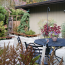 A nicely designed private patio and outdoor space with raised beds, lots of vegetation, and privacy fence.