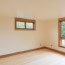 A bedroom with bamboo floors, , warm wood trim, large windows, and accent lighting.